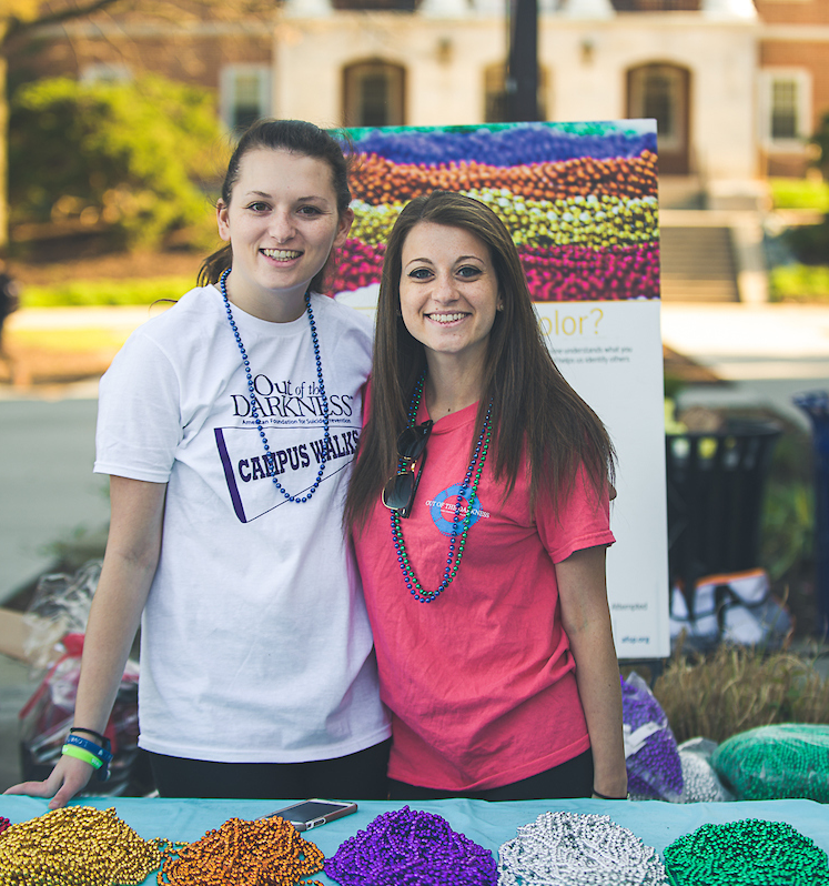 Two smiling college women wearing honor beads at Campus Walk