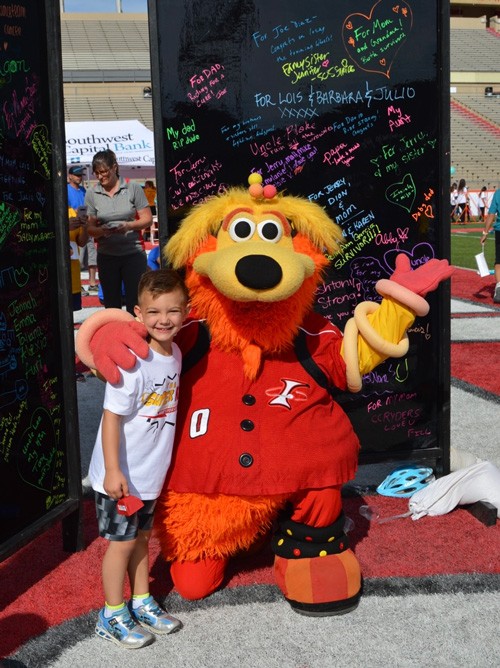 Liam with Orbit by the Dedication Board at the Lobo Cancer Challenge 2019