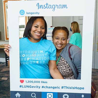 Two women at HOPE Summit holding an Instagram photo frame