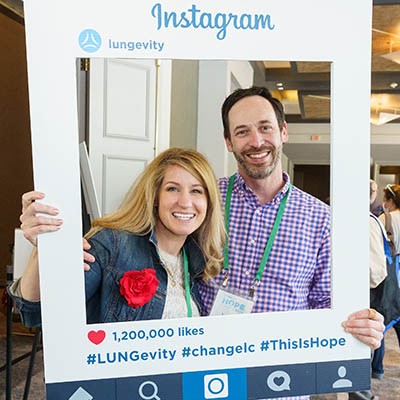 A man and a woman at HOPE Summit holding an Instagram photo frame