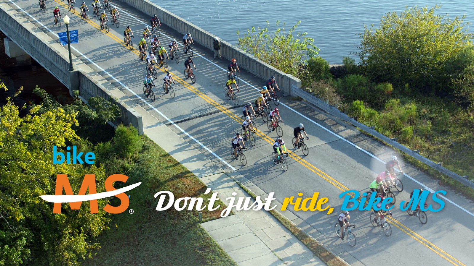Facebook cover image depicting overhead shot of cyclists on a bridge
