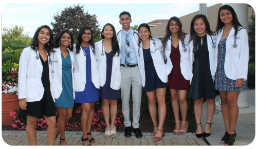 Educational Equity Scholarship recipient Rea Mittal and her friends wears their white doctor's coats during a Penn State College of Medicine ceremony