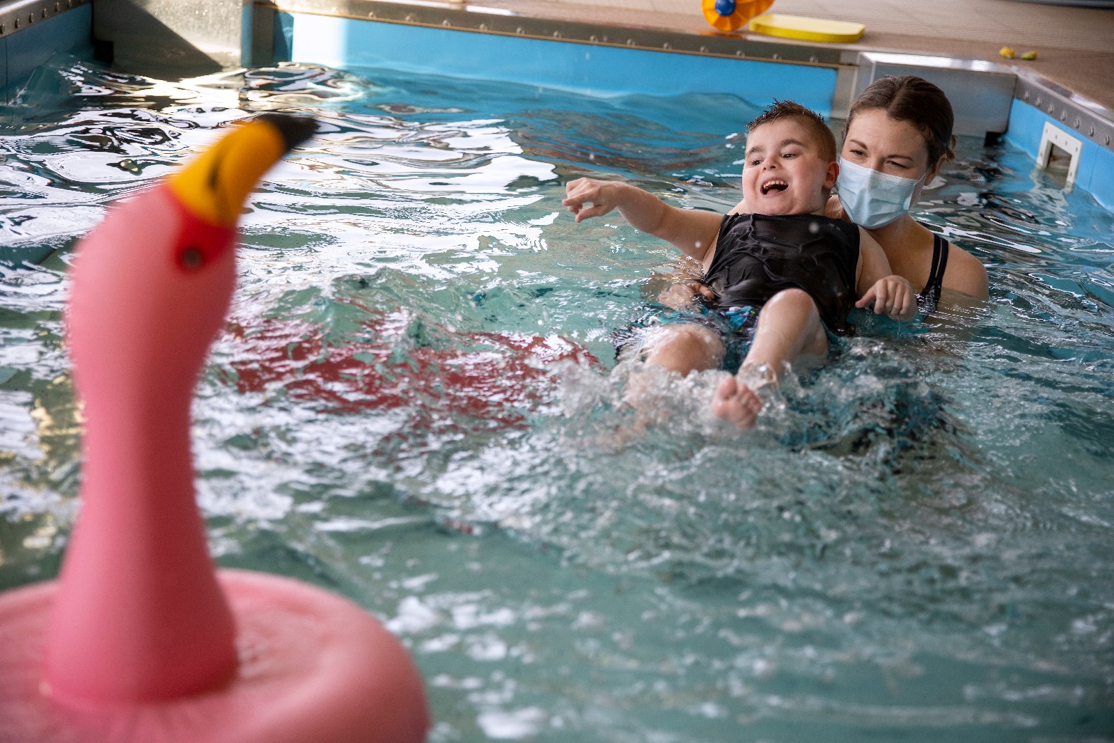 Penn State Health physical therapist Taylor Swingle holds Miracle Child Gannon in the pool during an aquatherapy session